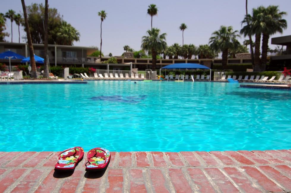 Sandals Next To Large Empty Swimming Pool In Palm Springs, California; 