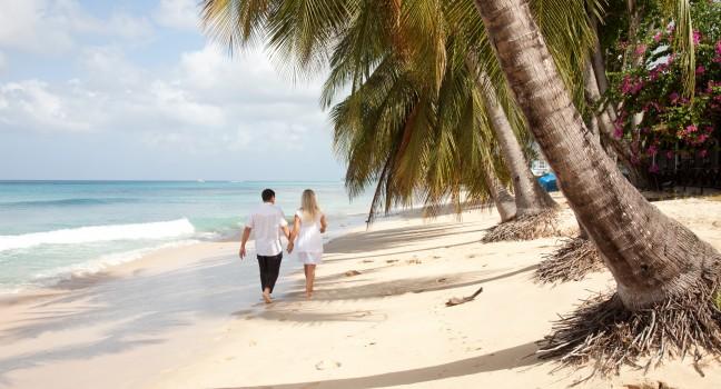 Couple walking by the sea in Barbados 
