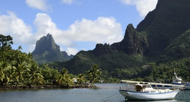 Boat in Cooks Bay with Moua Puta mountain in the background on the tropical pacific island of Moorea, near Tahiti in French Polynesia.; 