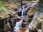 Watkins Glen waterfall in woods with rocks and stream in Watkins Glen state park in New York State