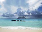 The group of tourists riding horses in Caribbean sea on Half Moon Cay, The Bahamas.