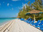 Lounge chairs on a white sand beach, Coco Cay, Bahamas.