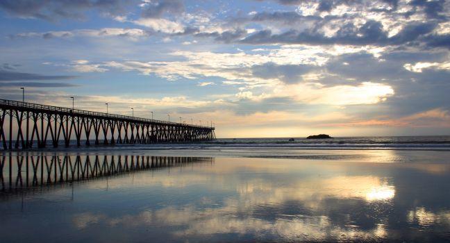 Rosarito pier and beach with clouds reflecting in the surf taken at sunset- Rosarito, Baja, Mexico,.